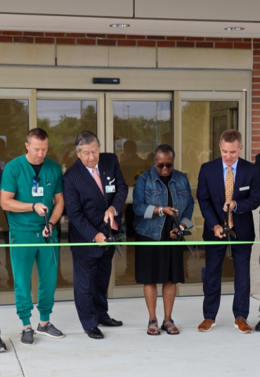 John and group at a ribbon cutting event